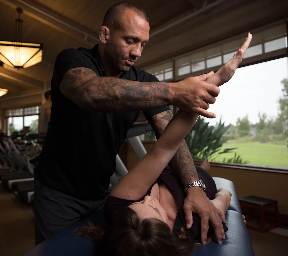 Dominick Nusdeu assessing a client's shoulder range of motion at Theorem